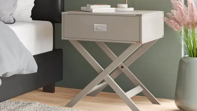 Tan nightstand next to bed in bedroom.
