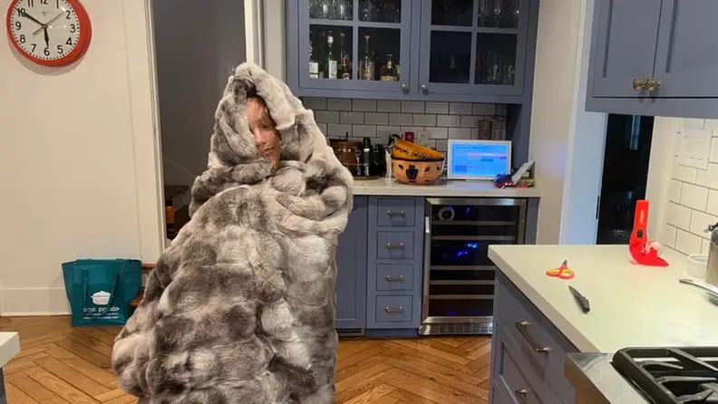 A kid wrapped up in a faux fur blanket