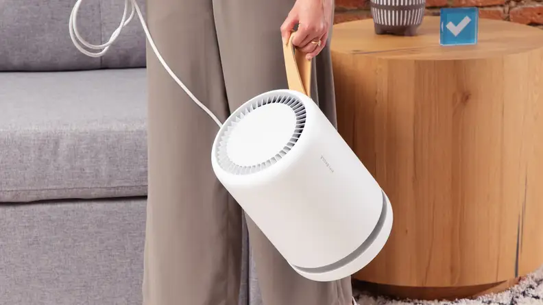 The Molekule is shown carried by its faux leather strap.