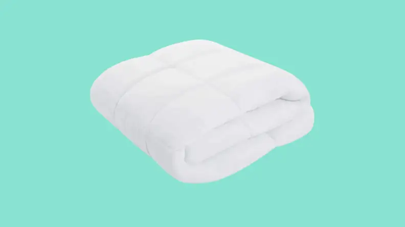 Folded comforter against blue background