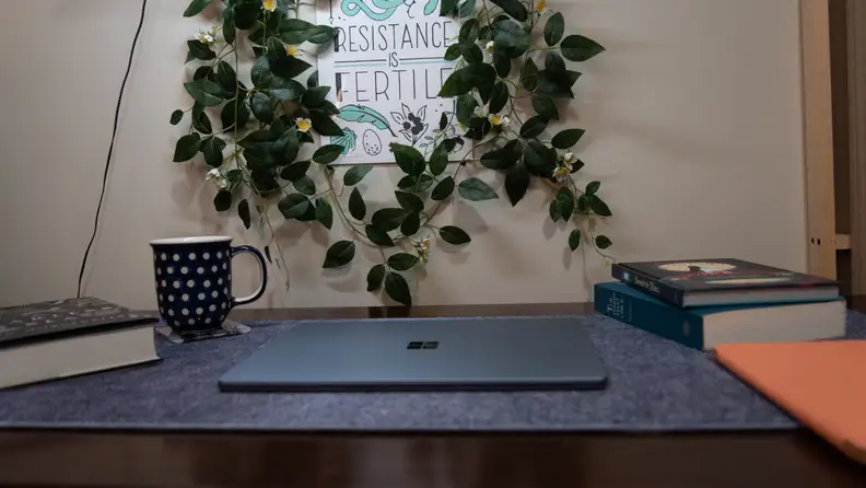 The laptop is closed on the desktop.