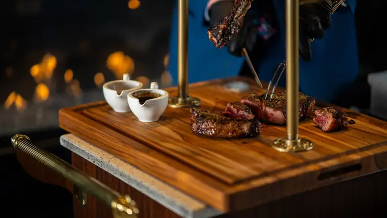 Hanging tomahawk being cut on a wooden board by the server