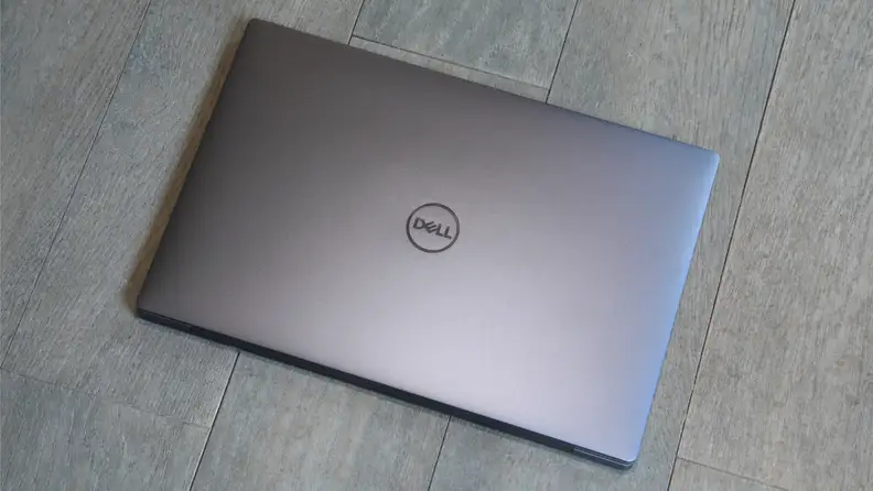 A closed slate grey Dell XPS 13 laptop with a Dell logo on top