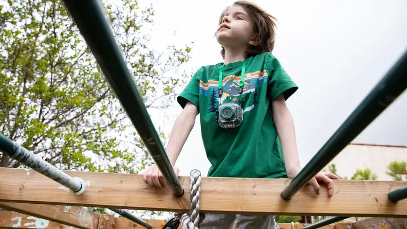 A child uses his prograce camera when climbing outside