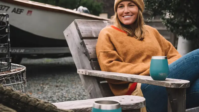 Woman next to a Yeti wine tumbler