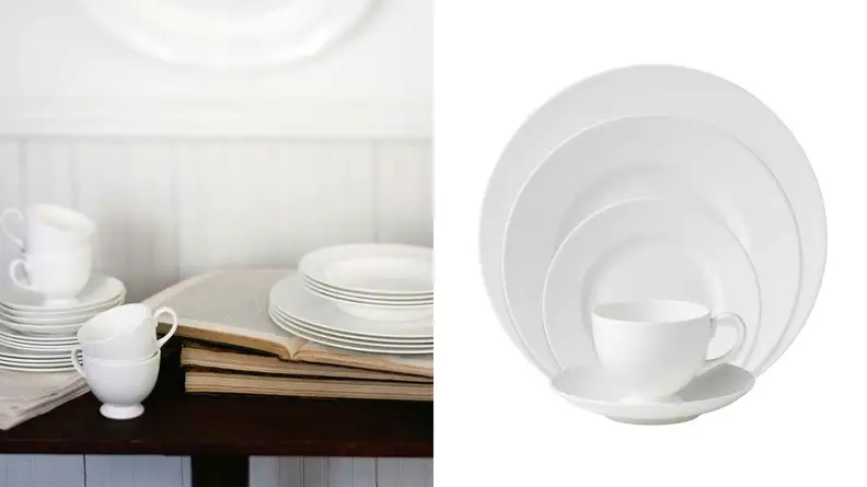 Wedgwood dinnerware stacked on top of books.