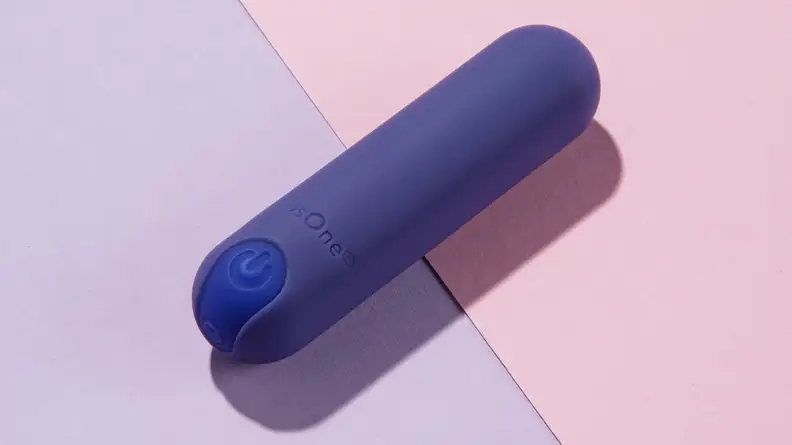 A dark blue PlusOne Bullet Vibrator on top of a pink and purple background.