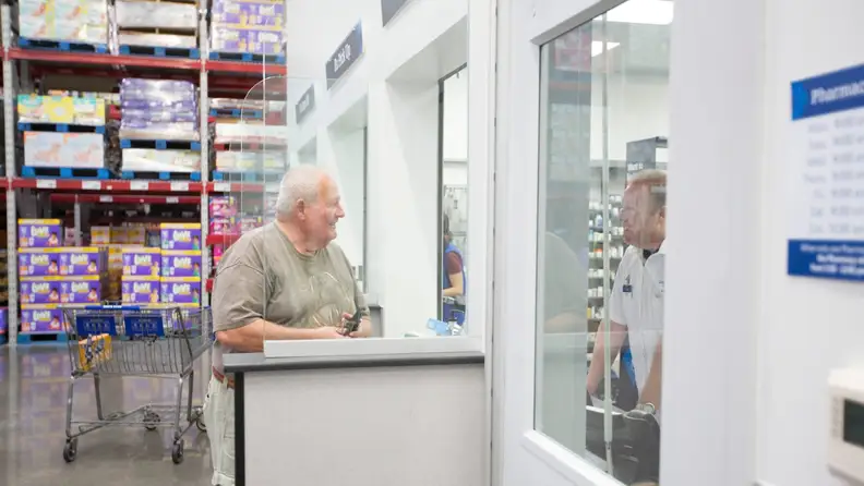 A Sam’s Club member picks up a prescription at the in-store pharmacy counter.