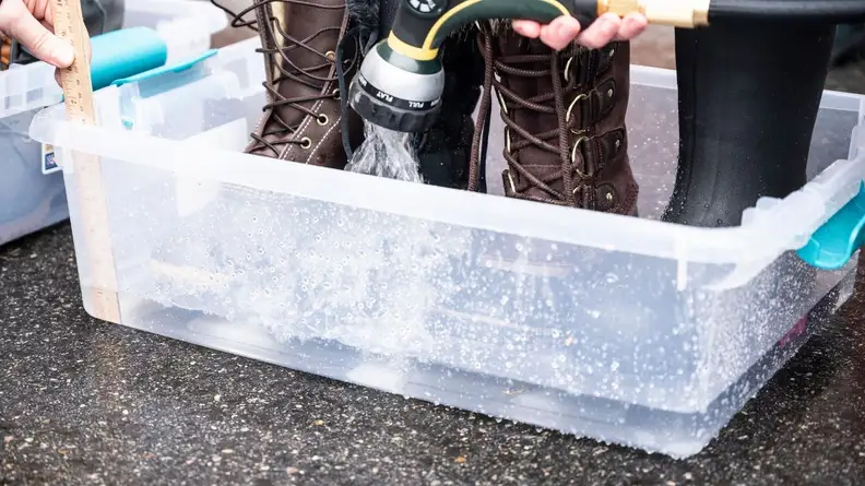 Testing winter boots in a tub of ice water.