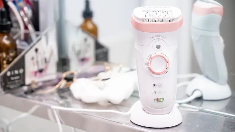 The Braun Silk-Epil 9 sitting on a sink in its holder.