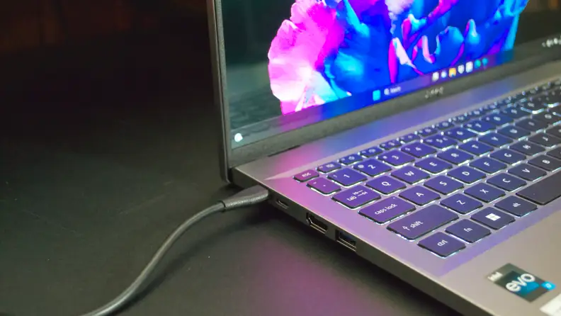 A close up of a power cable connected to a laptop.