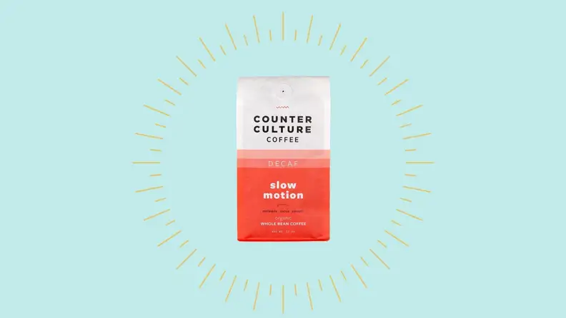 A bag of decaf coffee against a bright blue background.