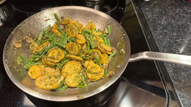 Mixed veggies sautéing on stainless steel skillet