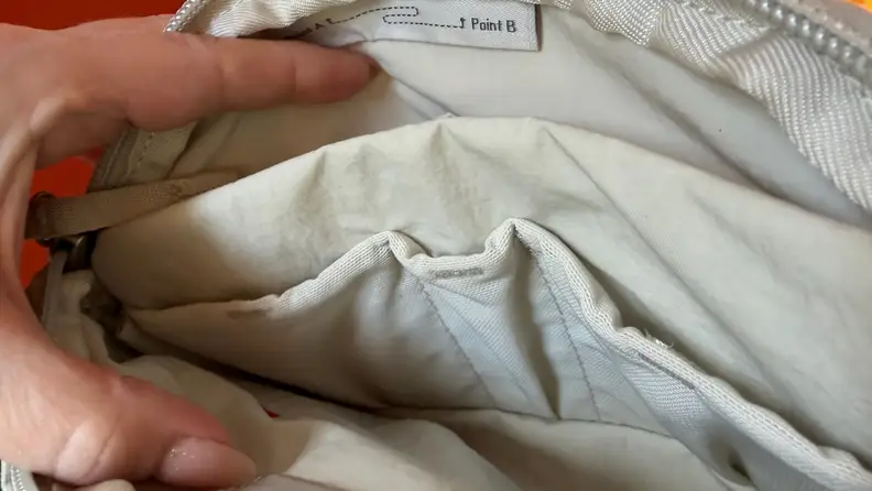The inside of a white peak design crossbody bag