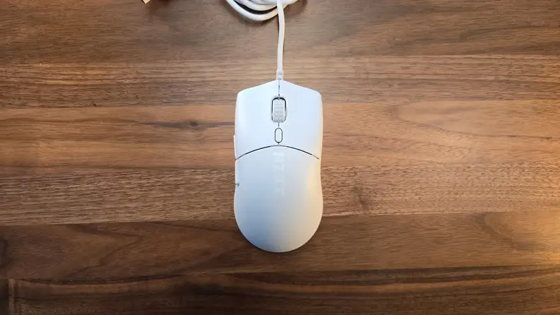 The NZXT Lift 2 Symm mouse on a wood table.