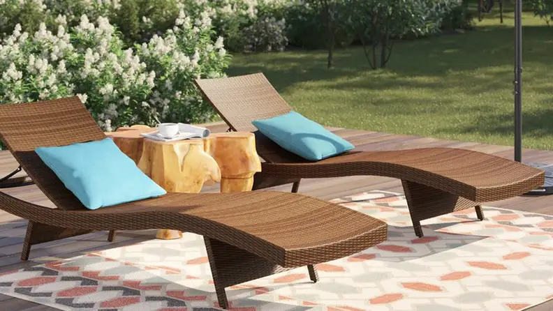 Two wooden chaise lounges sit on a sunny patio.