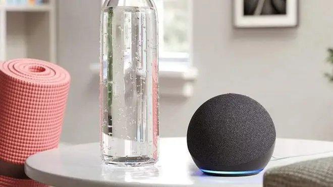 Amazon Echo Dot on counter next to water bottle and pink yoga mat