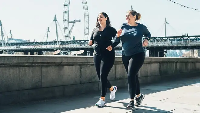two woman in activewear walking on bridge
