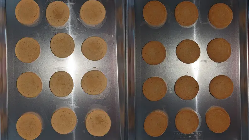 Two baking sheets with rows of different toned sugar cookies.