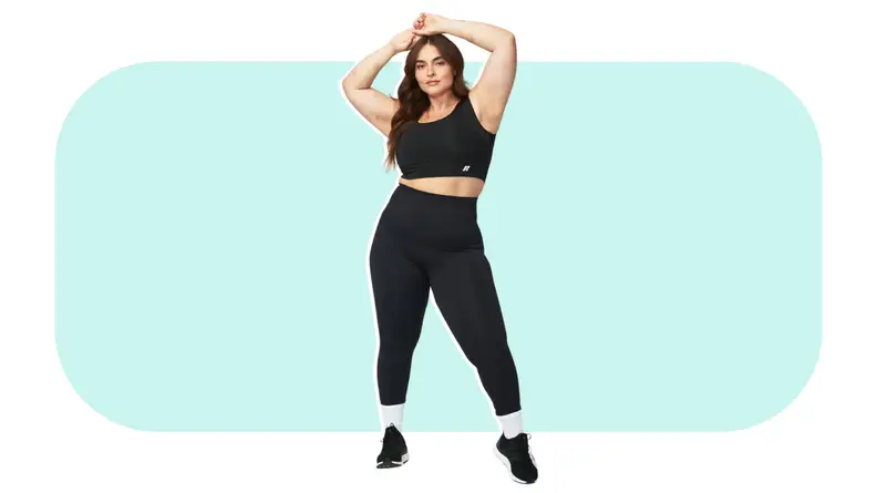 Model posing with arms above head while showcasing black Forme Power Bra, workout leggings, and sneakers.