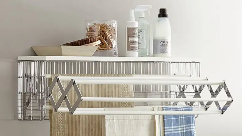 Pottery Barn's collapsible drying rack provides extra storage space for spray bottles, clothespins, and other necessities.