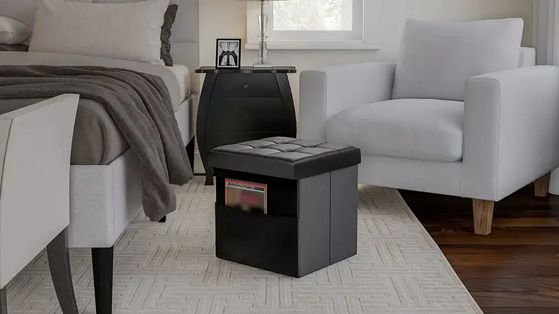 A living room with a square, brown ottoman in the center