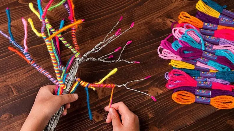 A person making a yarn tree.