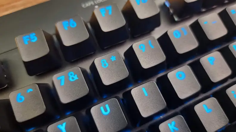 A close up of the Logitech G Pro keyboard keys, that are glowing with blue light.