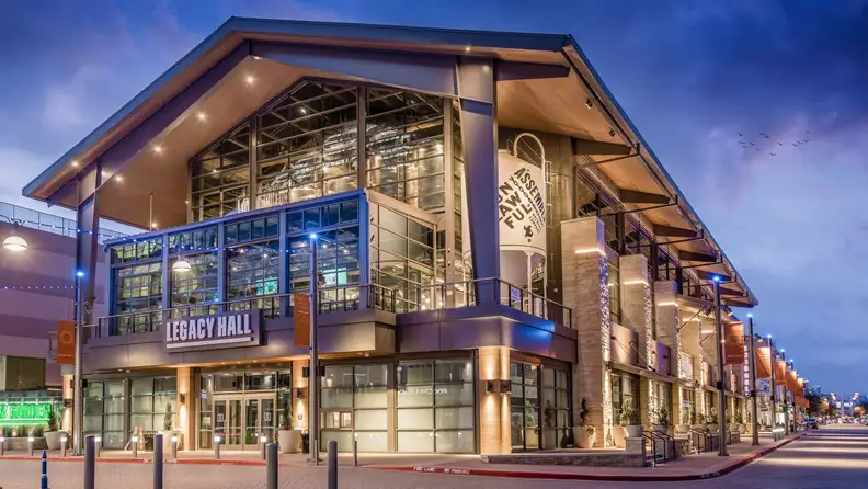 Twilight exterior of Legacy Hall with exposed steel and glass