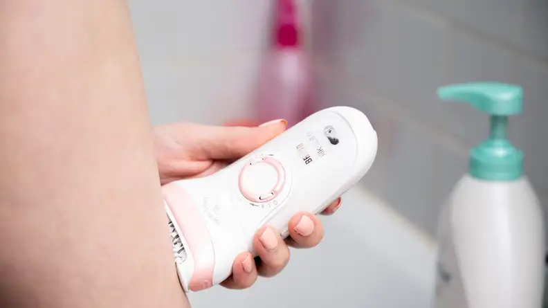 A person using the Braun Silk-Epil 9 on their leg.