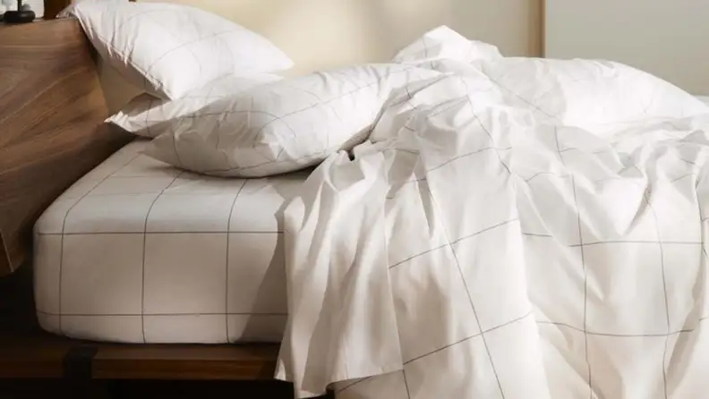 a bed made with grid patterned sateen sheets