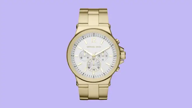 Gold designer watch against a purple background