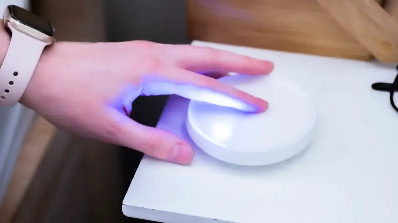 a person's hand touches the top of the Dodow
