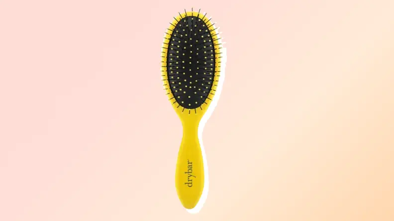 One of the best hair brushes from Drybar against a red and orange background.