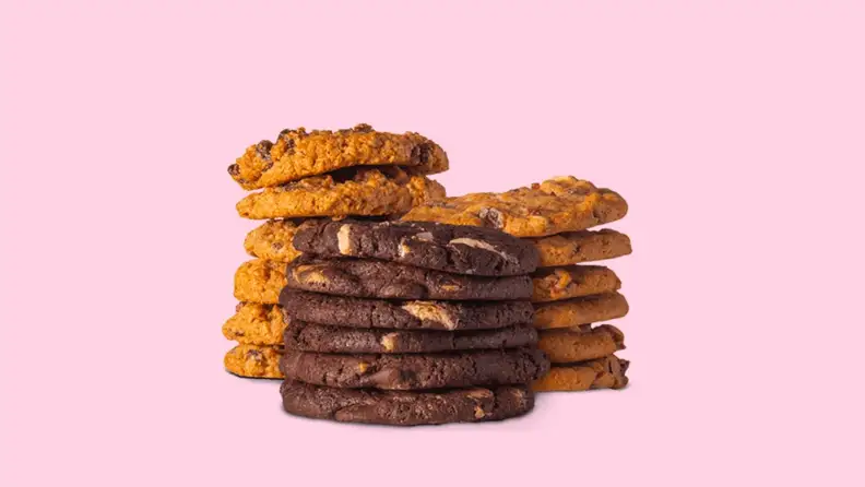 Three stacks of cookies against a light pink background.