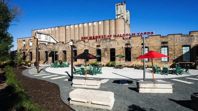 Brick exterior of Malcolm Yards with grain silos and outdoor seating