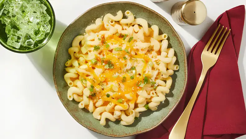 Prepared meal for one person featuring macaroni with cheese and herbs, served as a single-portion vegetarian dish.