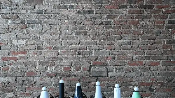 The barrel of several hair dryers facing upward with ping pong balls hovering over them.