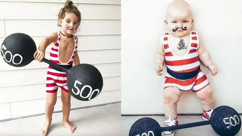 Children dressed up in strong man costume while holding barbell prop.