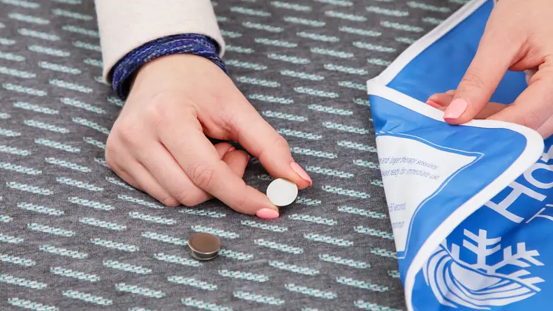 A person putting a heat sensor onto the Tuft & Needle Mint hybrid mattress.