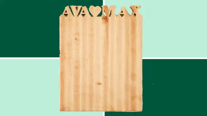 A Personalized Cutting Board from Uncommon Goods on a dark and light green background.