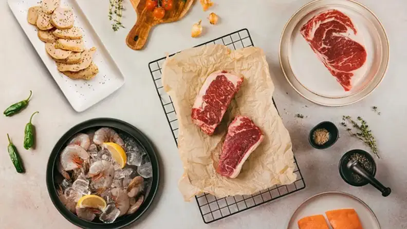 A collection of meats and shellfish from Crowd Cow on a surface.