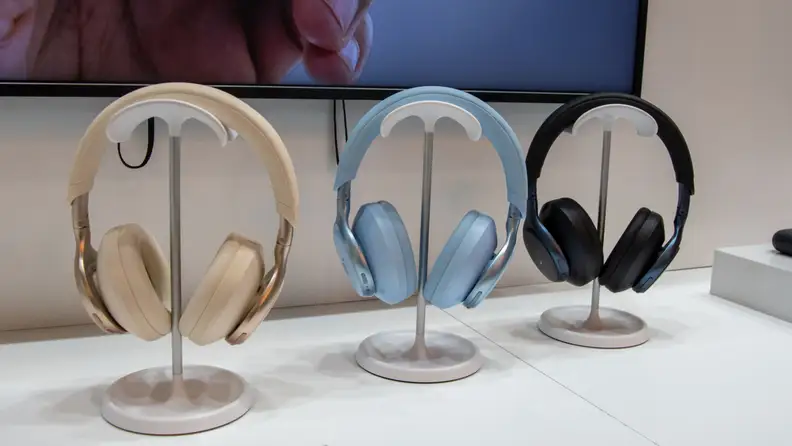 Three over the ear headphones side by side on a stands.