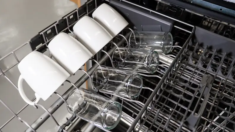 The third rack of the KitchenAid KDTM404KPS dishwasher with mugs and glasses on one side of it.