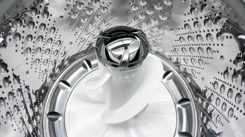 A shot of the interior of the LG WT7305CV Top-loading Washing Machine's drum, with a focus on its central pole agitator.
