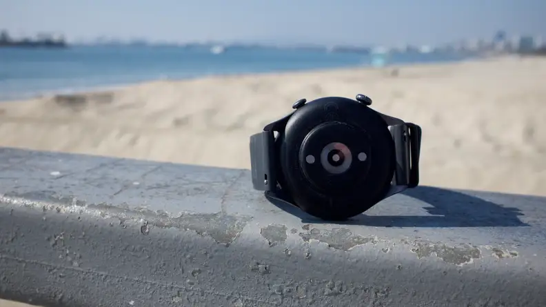 The back of the GTR 3, which houses the fitness sensors, with a beach in the background.