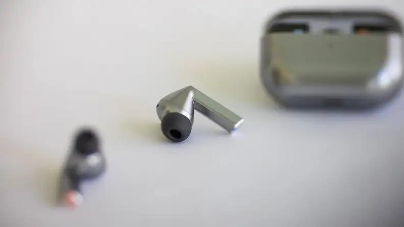 The Samsung Galaxy Buds3 Pro earbuds in front of its charging case.
