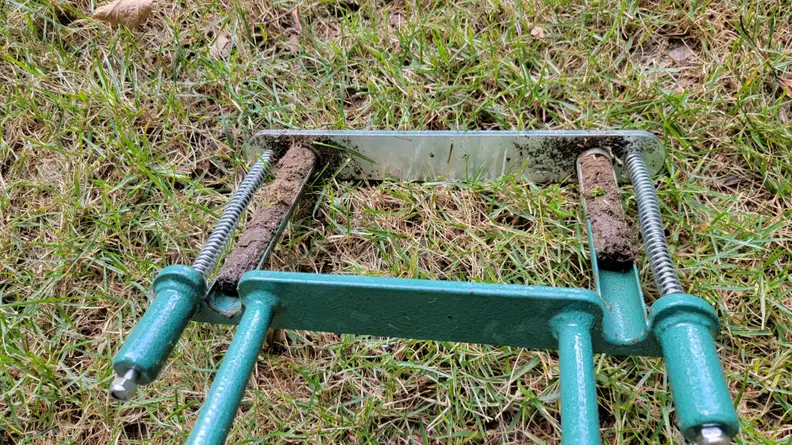The spring and core design of the opmeiro aerator on grassy ground.