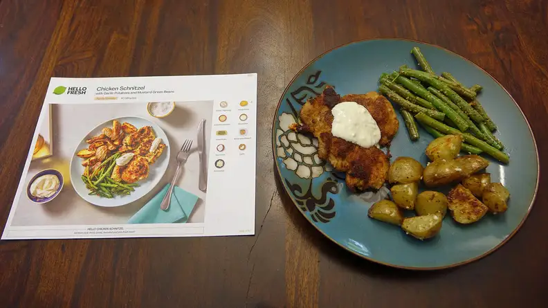 The Chicken Schnitzel with Garlic Potatoes and Mustard Green Beans beside a recipe card.