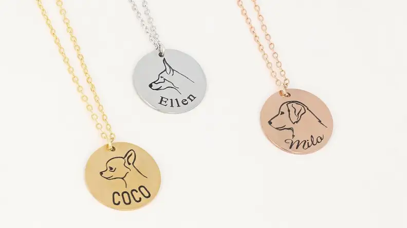 An image of several jewelry pendants featuring dog profiles and names.